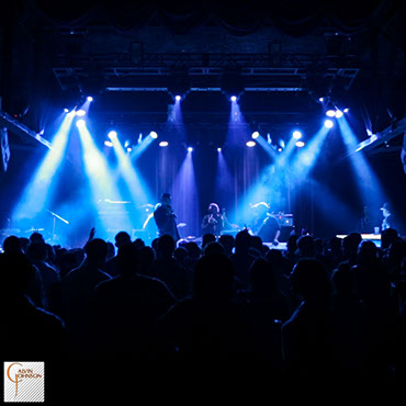 Hip Hop artist B.o.B performing in front of white beams of light at a concert with DJ Shawty Slim.