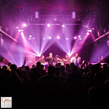 Hip Hop artist B.o.B performing in front of magenta and pink beams of light at a concert with DJ Shawty Slim.