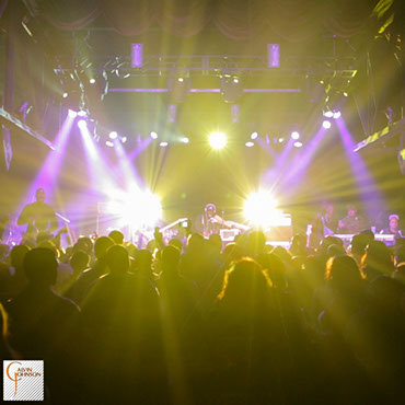 Hip Hop artist B.o.B performing in front of purple and white beams of light at a concert with DJ Shawty Slim.
