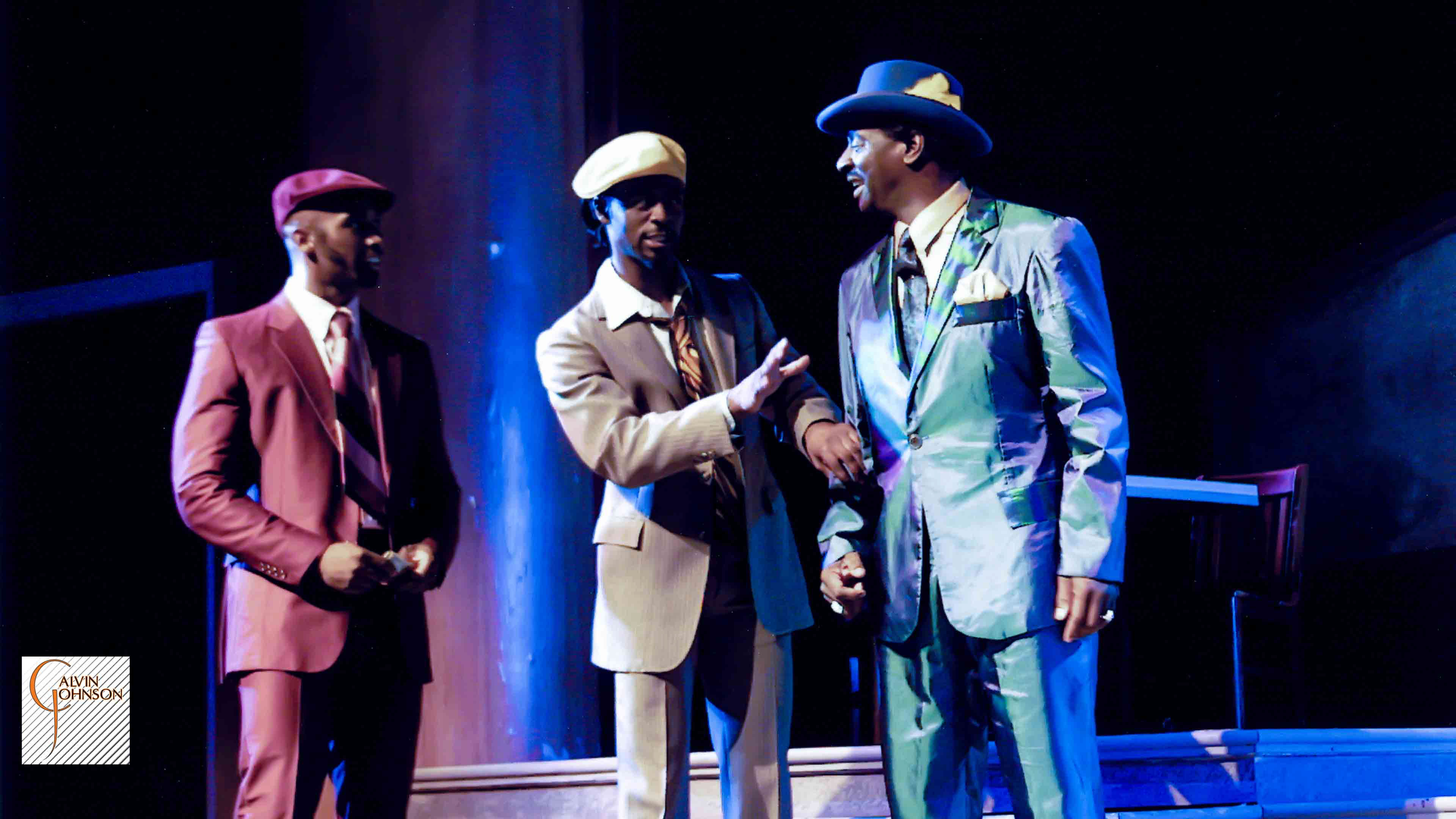 Three men dressed in guady suits talking to each other in the play "Flying Over Purgatory"